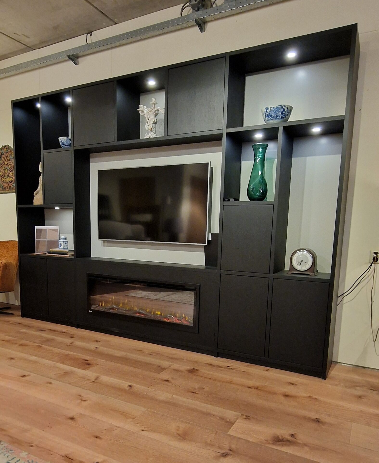 Zwarte tv kast op maat met grote vakken voor decoratie